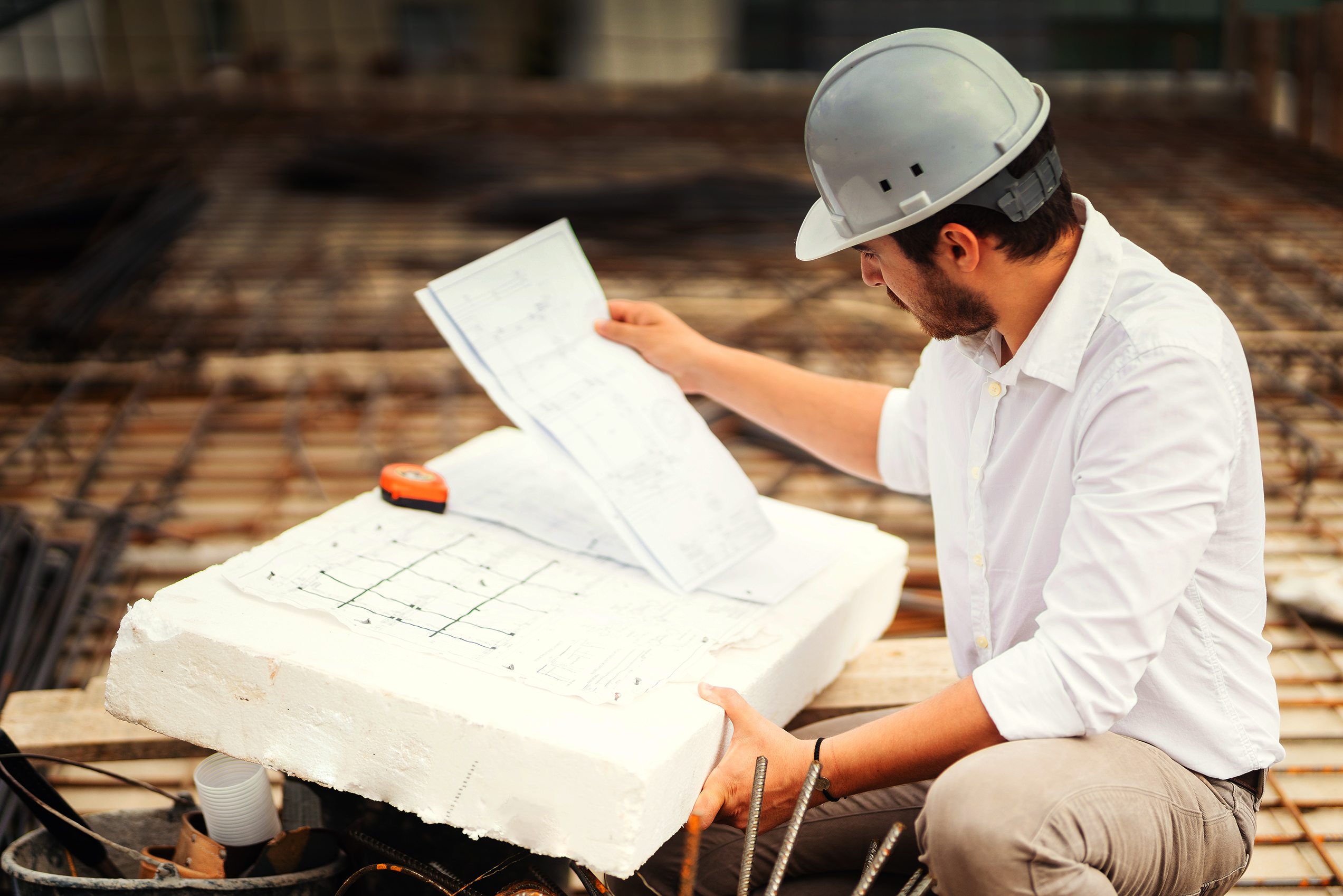 portrait of engineer reading plans on construction site